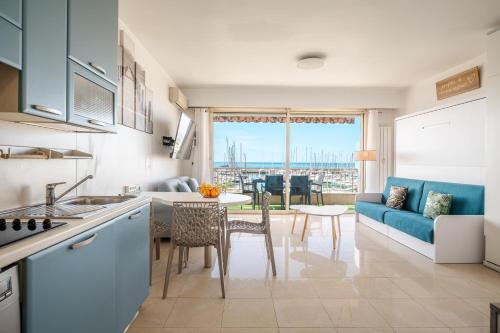 芒通La Grande Palmeraie - Spacieux studio avec vue mer, terrasse, port de Garavan的厨房以及带沙发和桌子的客厅。