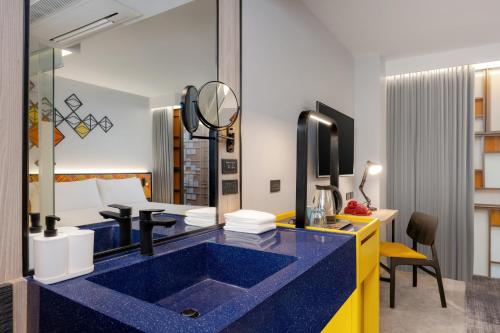 曼谷ibis Styles Bangkok Silom的客房内的浴室设有蓝色水槽