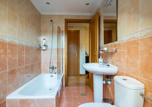 坎加斯-德奥尼斯Apartamento Irene céntrico con Wifi y parking coche tamaño medio Cangas de Onís的浴室配有卫生间、盥洗盆和浴缸。