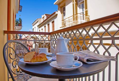 纳夫普利翁艾特马酒店 的阳台上的桌子上放着咖啡和面包