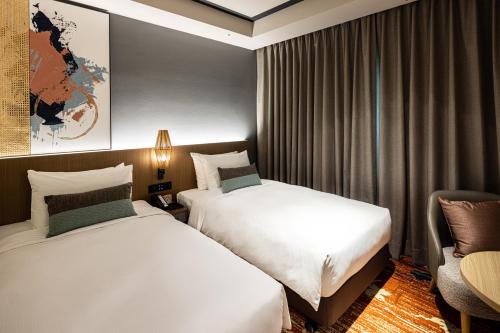 台北索拉利亚西铁饭店台北西门的酒店客房,配有两张床和椅子