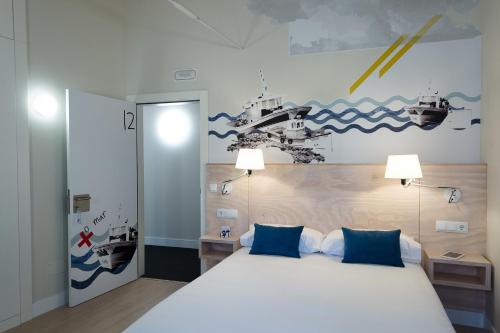 菲尼斯特雷特马迪克多班科阿祖尔旅馆的卧室配有带蓝色枕头的大型白色床