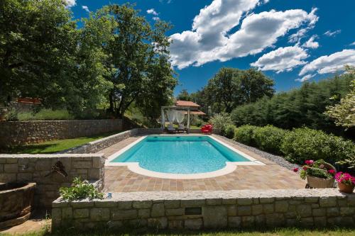 塞扎纳9b-The Resort的一座带石墙的花园内的游泳池