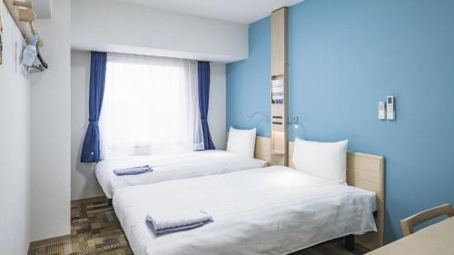 AsakaToyoko Inn Kita-asaka-eki Nishi-guchi的配有两张床铺的蓝色墙壁和窗户