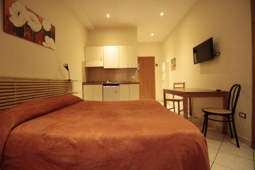 卡塔尼亚维斯特公寓酒店的一间卧室配有一张床,厨房配有桌子