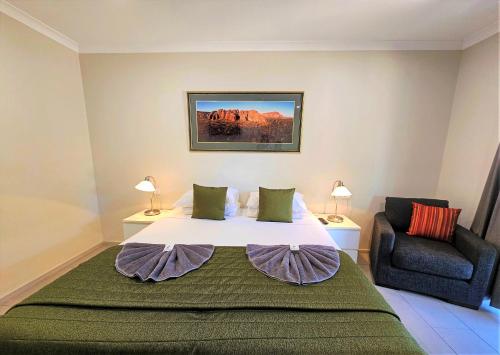 库努纳拉Lily Lagoon Resort的一间卧室配有一张大床和一把椅子
