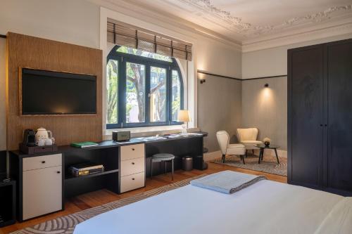 波尔图Casa da Marechal - Boutique Hotel by Oporto Collection - Adults Only的一间卧室配有一张床、一张书桌和一个窗户。