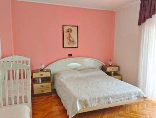 乌马格Apartment Danica 356的卧室设有粉红色的墙壁、一张床和一张婴儿床。