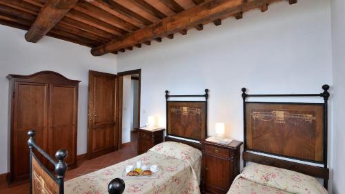 RoccalbegnaMelograno的一间卧室配有两张床和木制家具