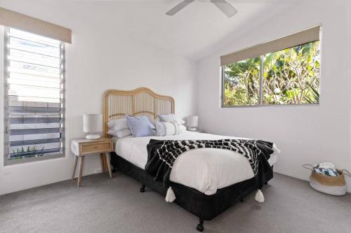 拜伦湾Marie's Byron Getaway的一间卧室设有一张大床和一个窗户。