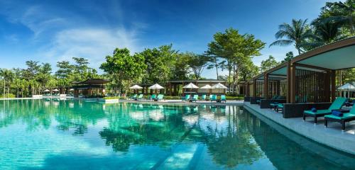 功孟海滩Dusit Thani Krabi Beach Resort - SHA Extra Plus的度假村的游泳池,设有蓝色的椅子和树木