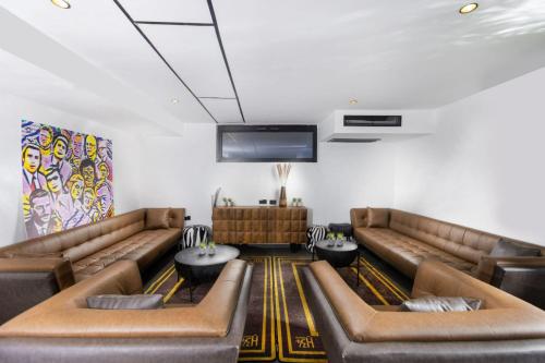 纳哈里亚מלון בוטיק H34的一间设有真皮沙发和平面电视的等候室