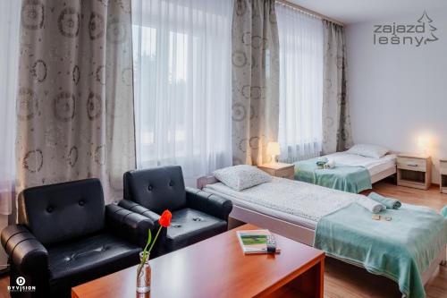 兹维日涅茨Zajazd Leśny Zwierzyniec的一间带两张床和一张沙发的客厅