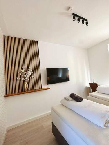 杜伊斯堡2 Schlafenzimmer 5 Betten的白色的客房配有床和平面电视。