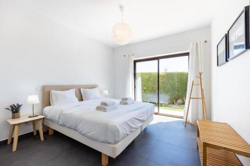 萨格里什Villa Botelha的白色的卧室设有床和大窗户
