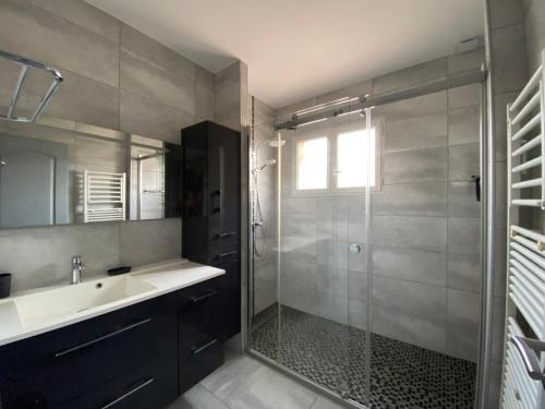勒米伊Villa Triskyl的一间带玻璃淋浴和水槽的浴室