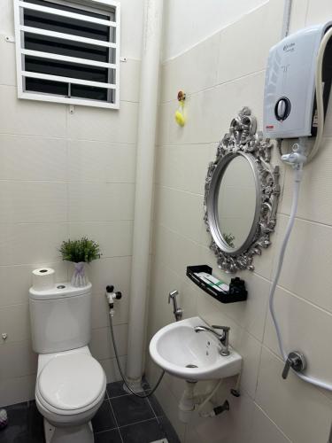麻坡The Amore Homestay的一间带卫生间、水槽和镜子的浴室