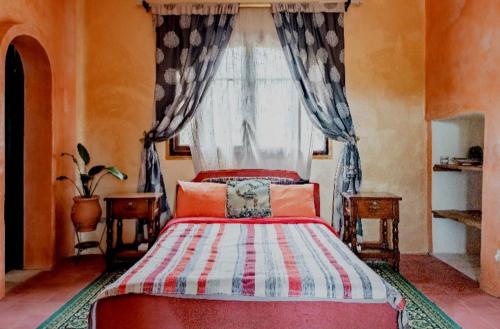 丹吉尔Hajrienne guest house的一间卧室设有红色的床和窗户。