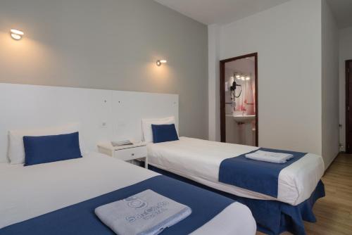 阿雷西费Hostal San Ginés的酒店客房,设有两张床和镜子