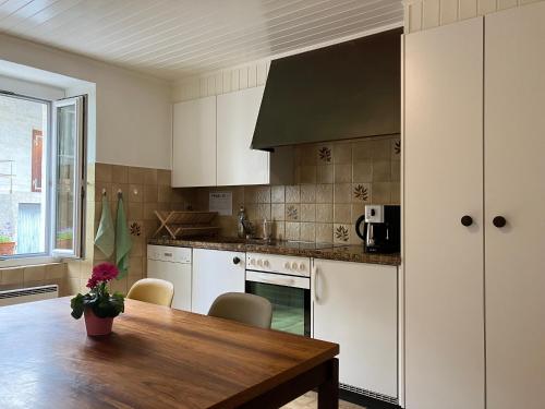 谢尔La Lanterne的厨房配有白色橱柜和木桌