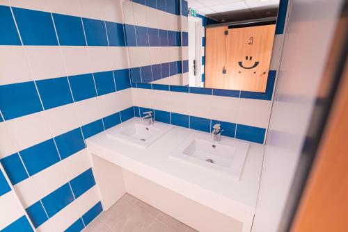 土伦Hostel Le Hüb Toulon的浴室设有2个水槽和镜子