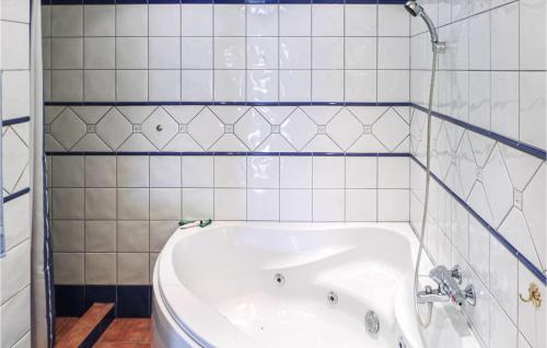 BaugeGorgeous Home In Matre With Wifi的浴室铺有白色瓷砖,配有浴缸。