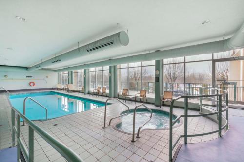米逊米森市洛奇贝斯特韦斯特优质酒店的大楼内带桌椅的大型游泳池