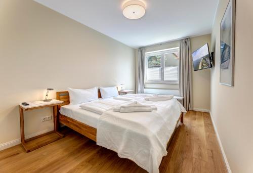 黑灵斯多夫Villa Madeleine App. 2的卧室配有一张大白色床和窗户