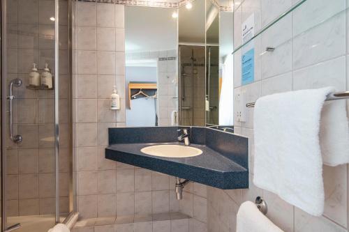 纽波特快捷假日新港酒店的一间带水槽和淋浴的浴室