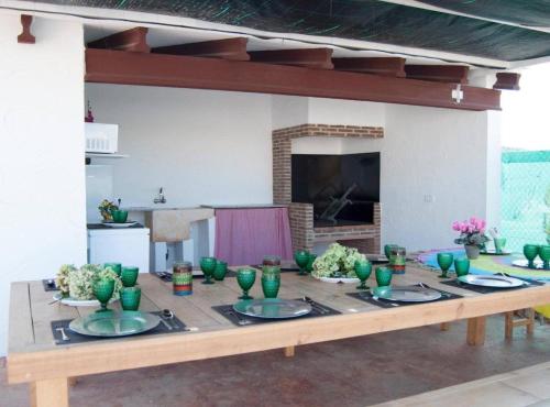 ChellaCasa Rural Frigols的一张木桌,上面放着绿色的碗和盘子