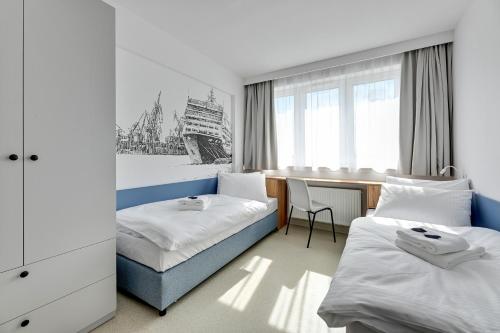 格丁尼亚Apartgdynia的酒店客房配有两张床和一张书桌