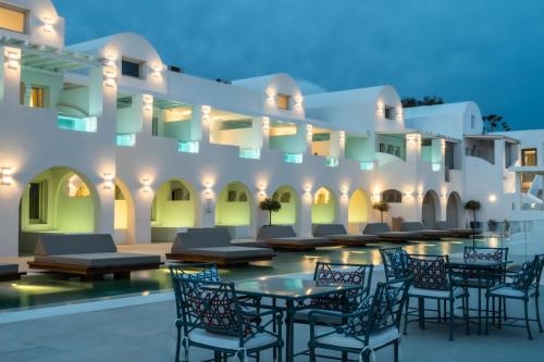费拉Apeiron Blue Santorini - Sustainable Adults Only 14 Plus的建筑前方的庭院配有桌椅