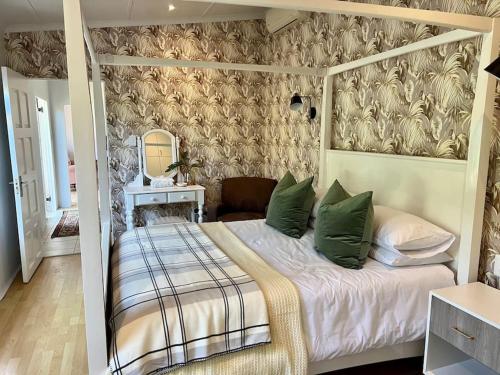 德班Stirling Cottage的一间卧室配有一张带绿色枕头的天蓬床