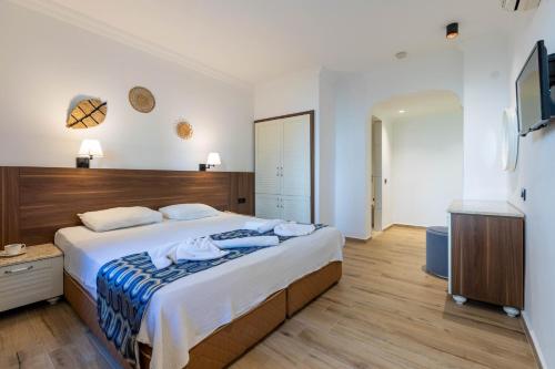 厄吕代尼兹布伦泽酒店的一间卧室配有一张大床和电视