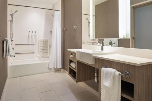 西萨克拉门托SpringHill Suites by Marriott West Sacramento的一间带两个盥洗盆和淋浴的浴室