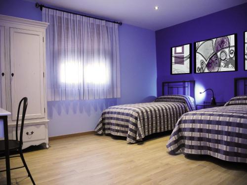 PeñalbaEl Balsetón的一间卧室设有两张床和紫色的墙壁