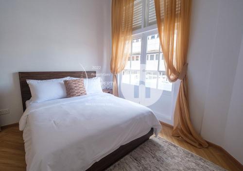 新加坡hovoh homes Bugis Rochor的一间卧室设有一张床和一个大窗户