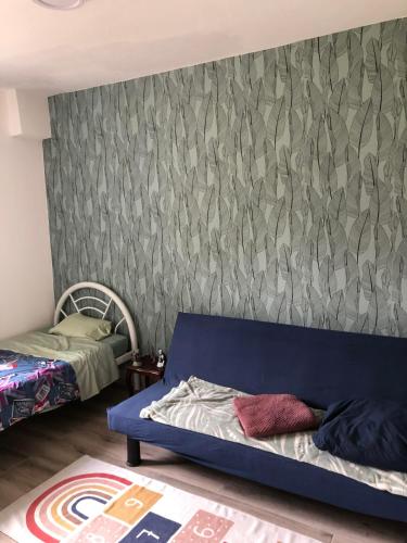 Saint-AignanTy case péi的卧室在墙上设有蓝色沙发