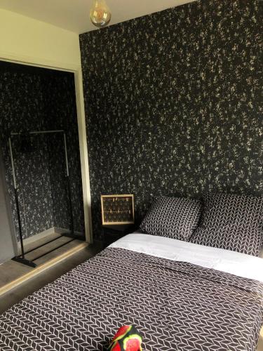 Saint-AignanTy case péi的一间卧室配有一张黑色墙壁的床