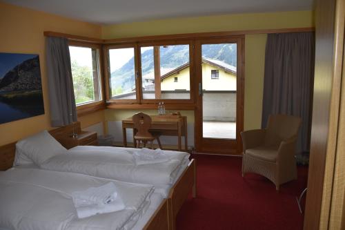 迪森蒂斯Hotel Pazzola的酒店客房设有两张床、一张书桌和窗户。