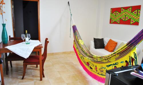 里奥阿查Hotel Majayura Sol的客房设有一张桌子和一张吊床。