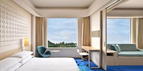 海得拉巴Fairfield by Marriott Hyderabad Gachibowli的配有一张床、一张书桌和一扇窗户的酒店客房