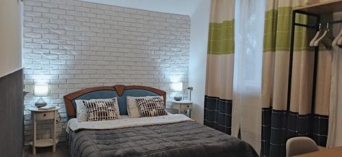 斯拉夫西克Захарова Оселя的一间卧室配有带枕头的床和砖墙