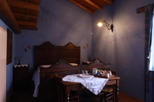 ArtogneAgriturismo Le Frise的卧室配有桌子和一张位于客房内的床