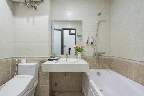 河内Granda Quan Hoa Apartment的一间带水槽、浴缸和卫生间的浴室