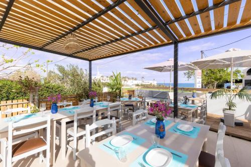 阿德里安诺斯坎波斯Banana Moon的餐厅设有白色的桌椅,享有海景。