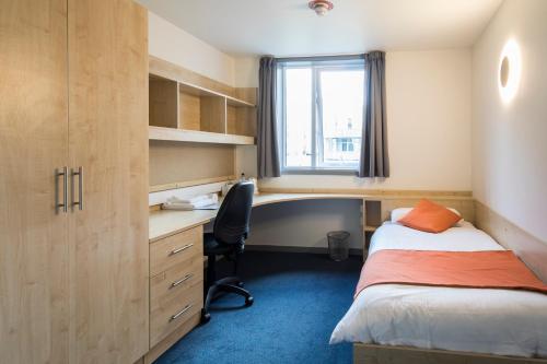 坎特伯雷Keynes College的一间卧室配有书桌、床、书桌和椅子