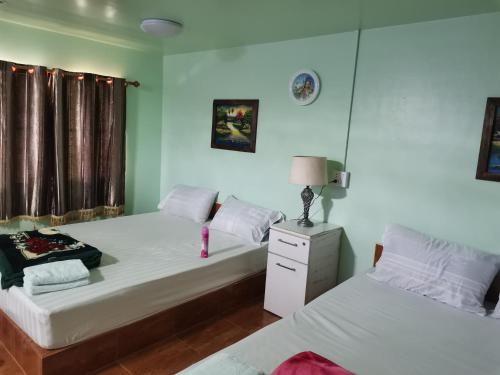 北碧布萨拉库姆度假酒店的一间卧室配有两张床和床头灯。