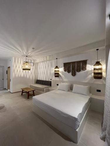 佩基罗德培福克斯蓝色公寓式酒店的白色卧室设有一张大床和一张沙发