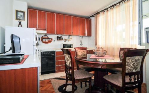 蒂瓦特Apartmani Andjelka的厨房配有桌椅和冰箱。